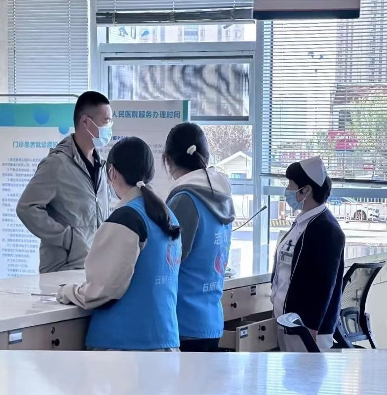 圖為志愿者在醫(yī)護人員指導下幫助患者咨詢 蒲公英服務中心供圖